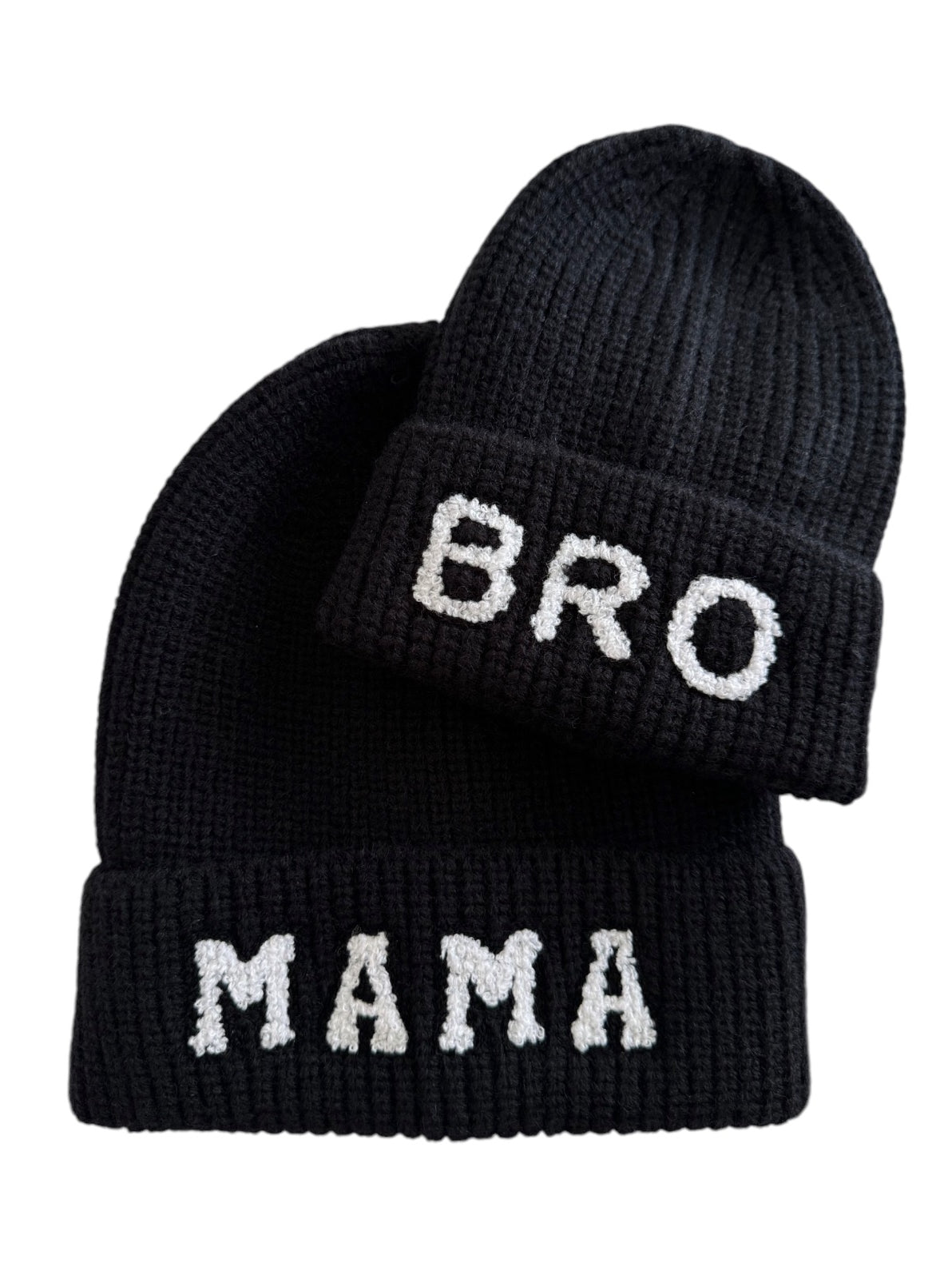 Two black knit beanies, one labeled "MAMA" and the other "BRO" in white lettering.