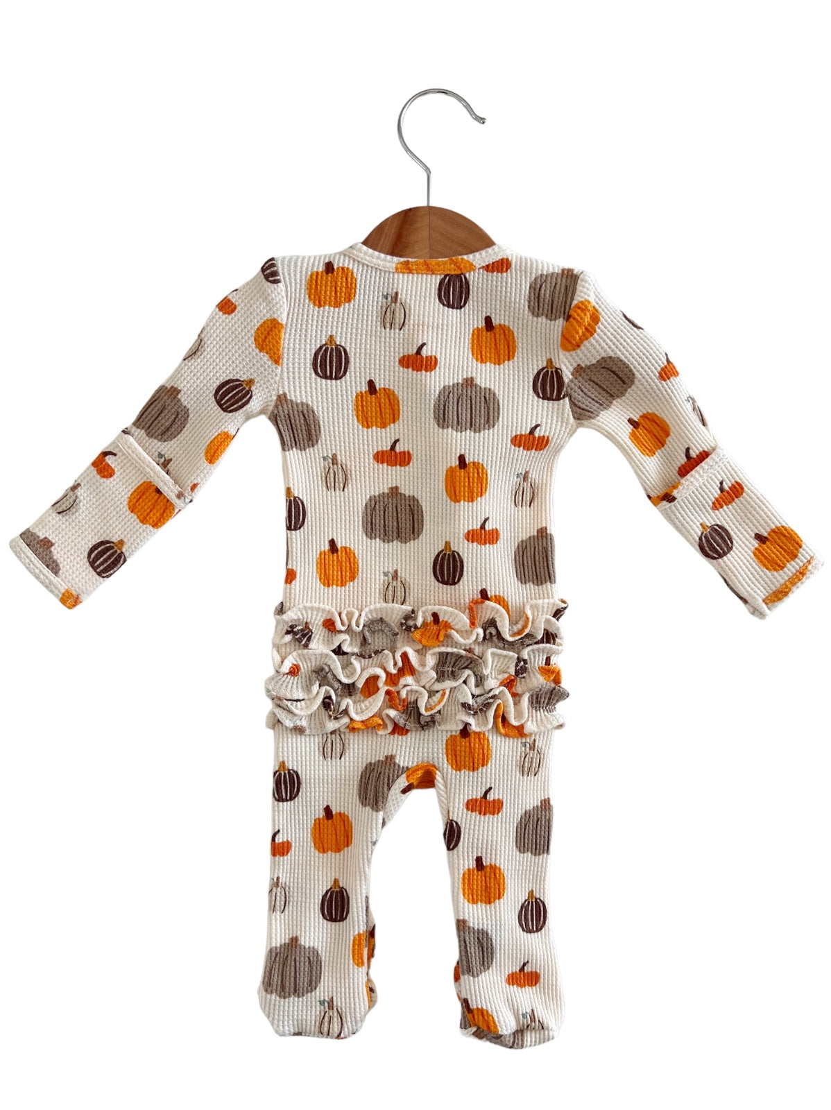 Toddler ribbed romper with colorful pumpkin print and ruffled hem, hanging on a wooden hanger.