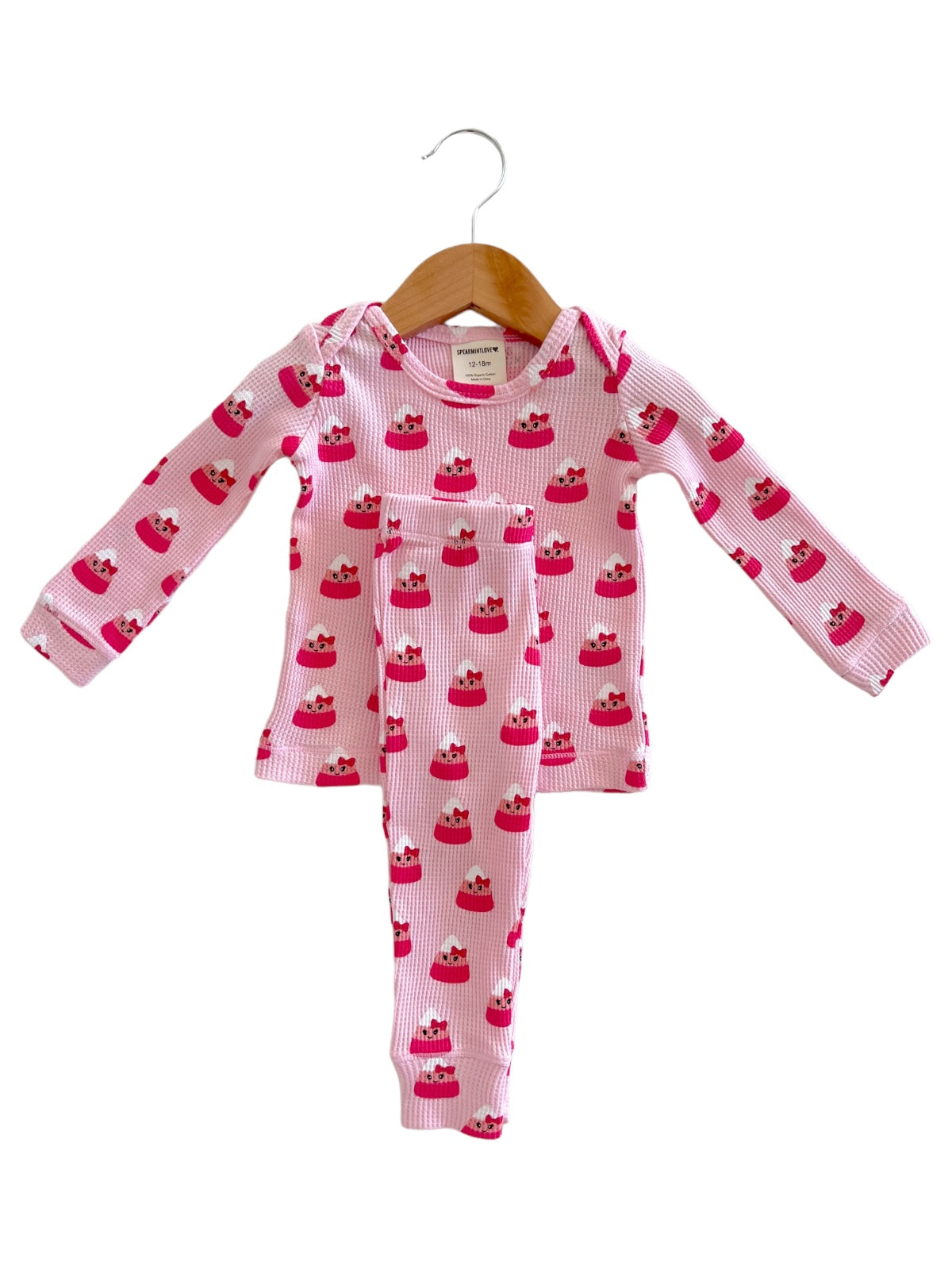 Pink pajama set with cupcake prints for kids, featuring a long-sleeve top and matching pants.
