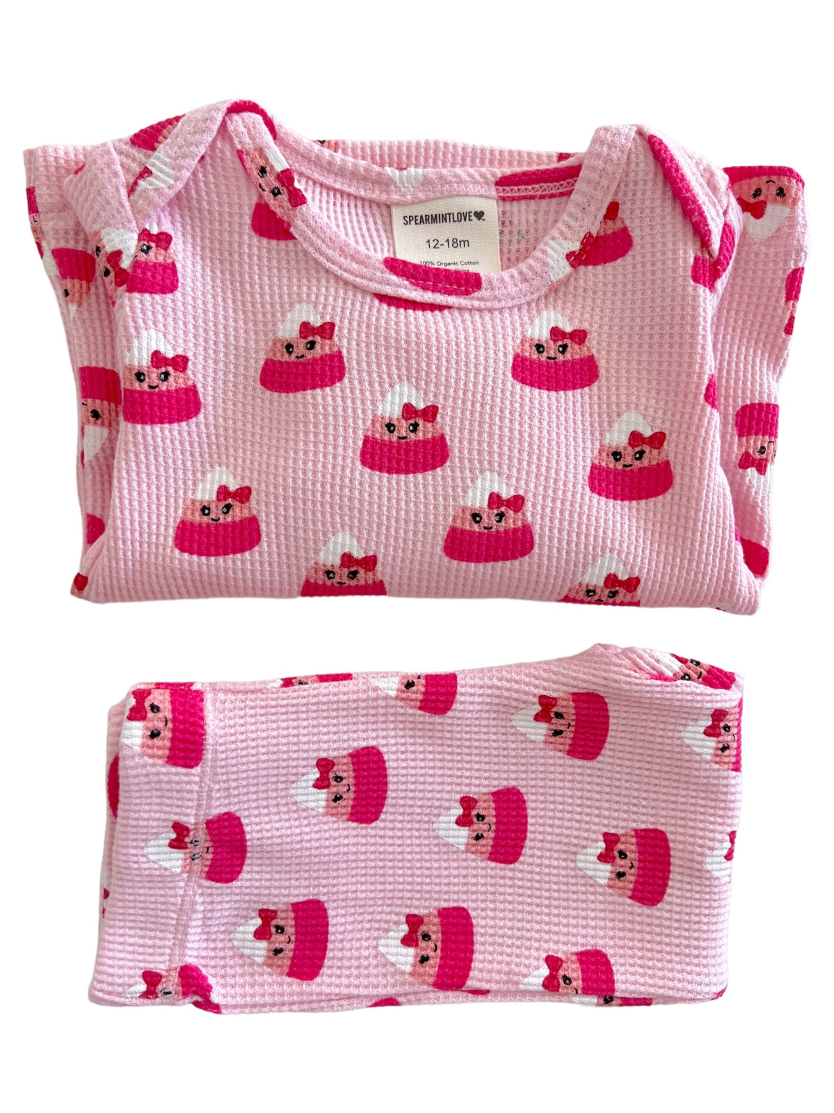 Pink infant pajamas featuring a cute cake pattern with red bows, labeled for size 12-18 months.