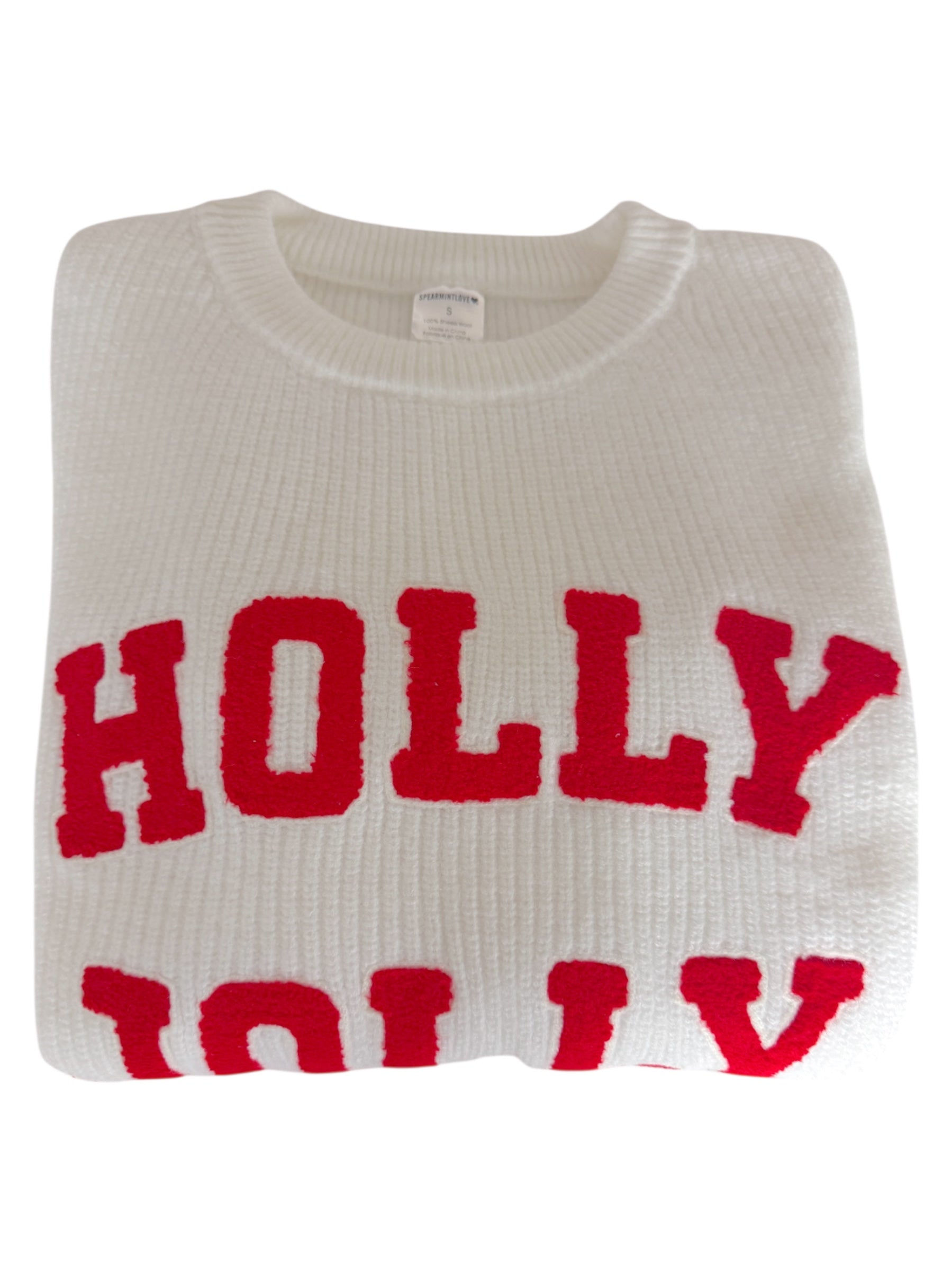 White sweater folded, featuring bold red text that reads "HOLLY JOLLY."