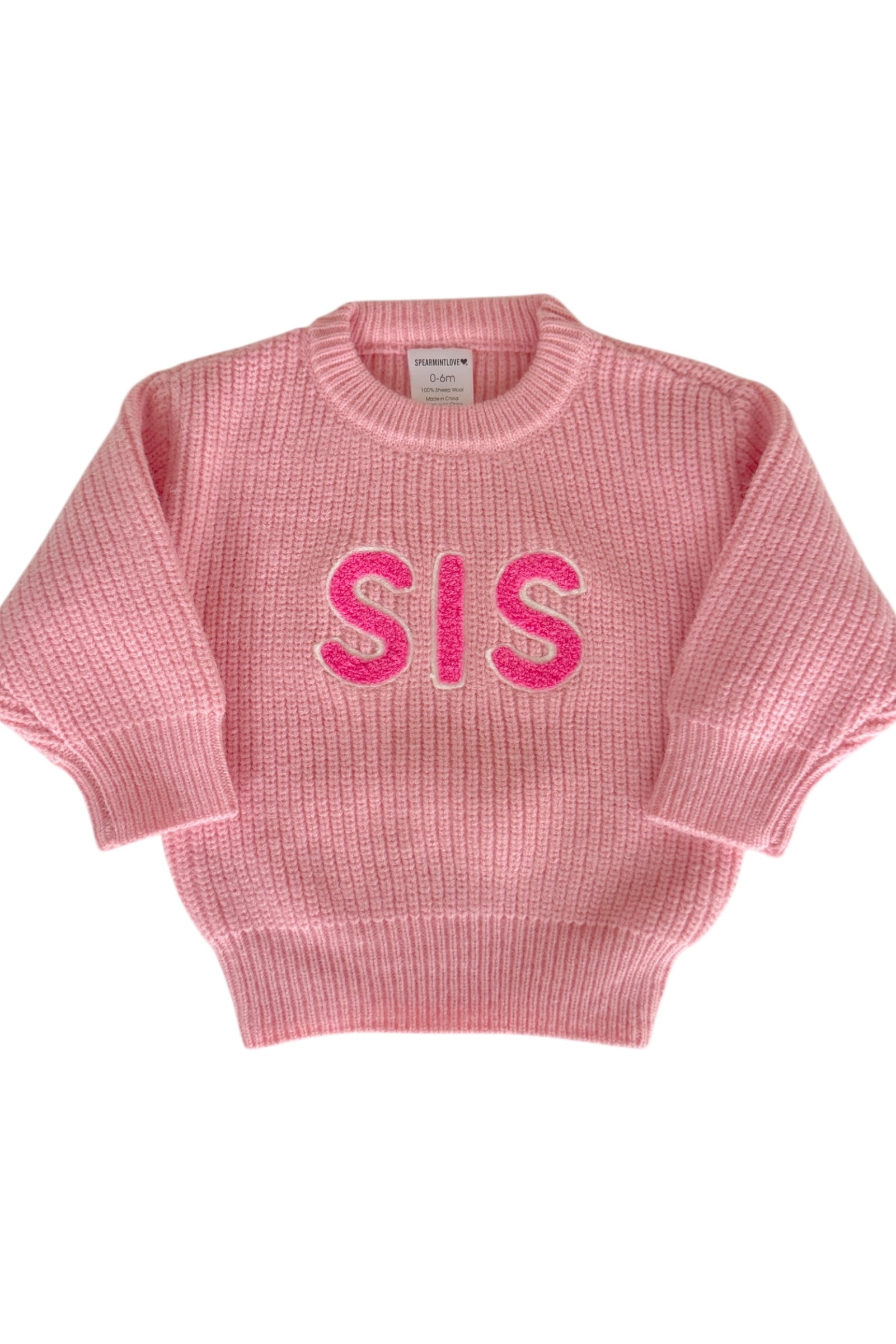 Pink knitted sweater with "SIS" in bright pink letters on the front, designed for infants and toddlers.
