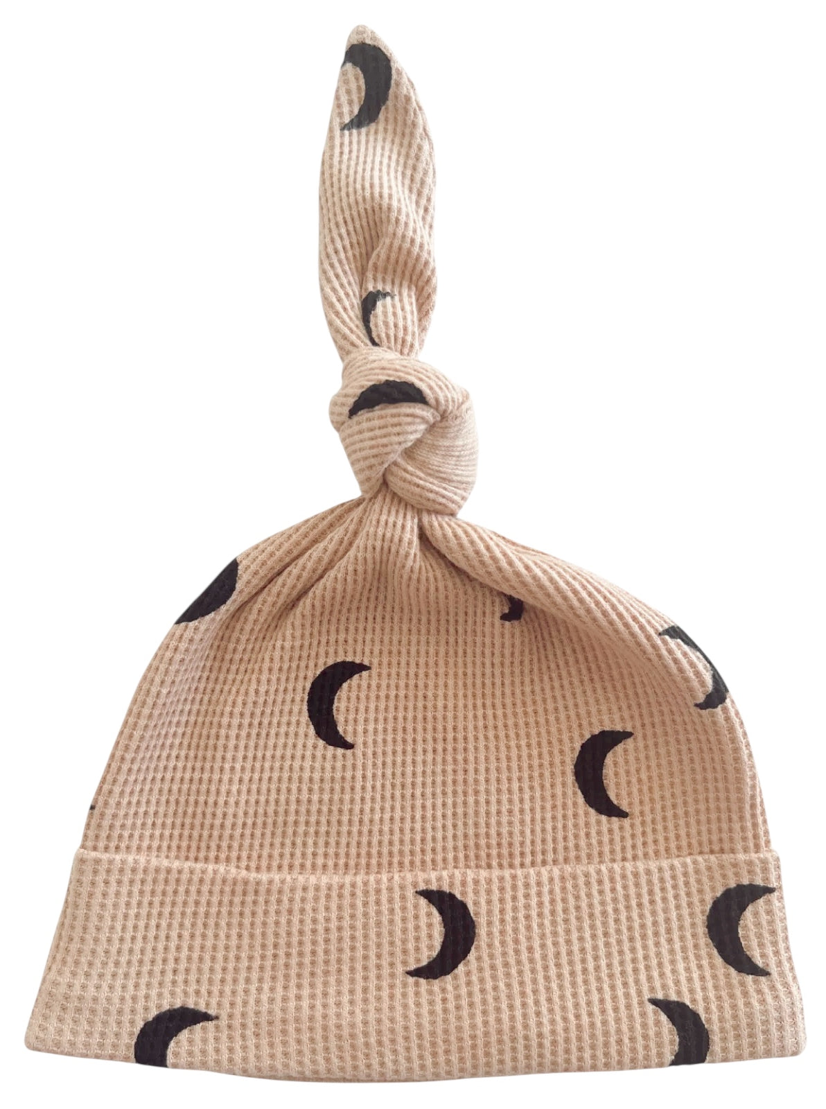 Beige baby hat with a knot on top, featuring black crescent moon patterns.
