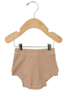 Beige waffle-knit shorts hanging on a wooden hanger against a white background.