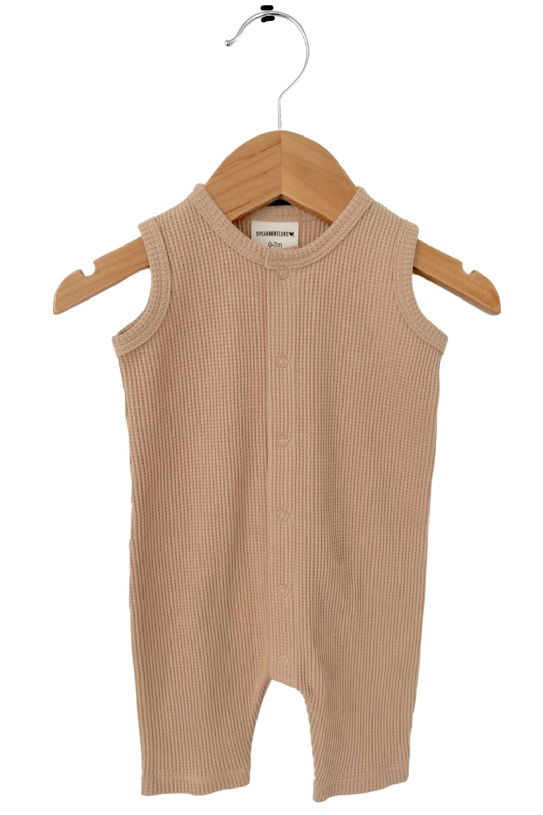 Beige sleeveless baby romper on a wooden hanger, featuring a ribbed texture and button closure.