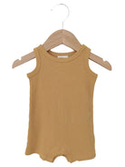 Mustard yellow ribbed tank onesie hanging on a wooden hanger.