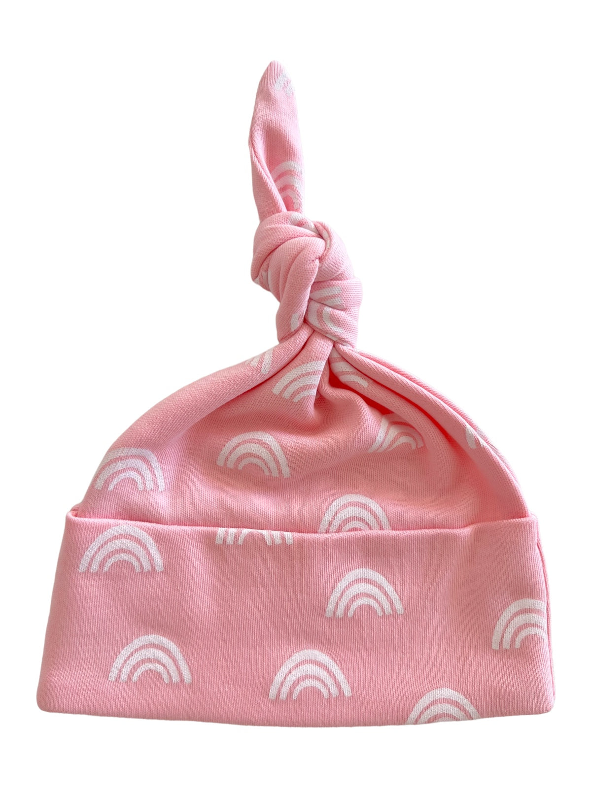 Pink baby hat featuring white rainbow patterns and a knotted top.