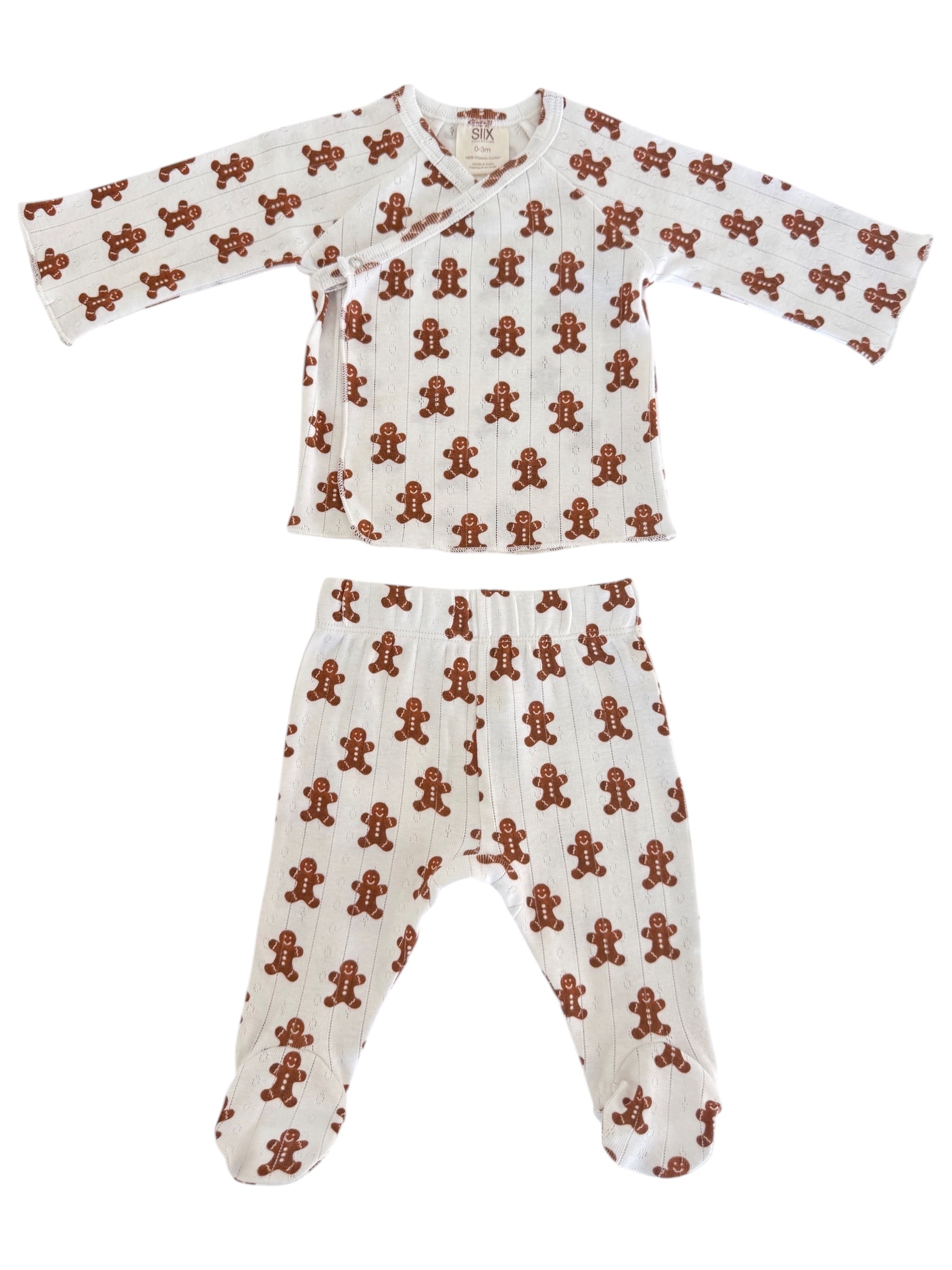 White infant pajamas with a gingerbread man pattern, featuring a top and pants set for cozy wear.