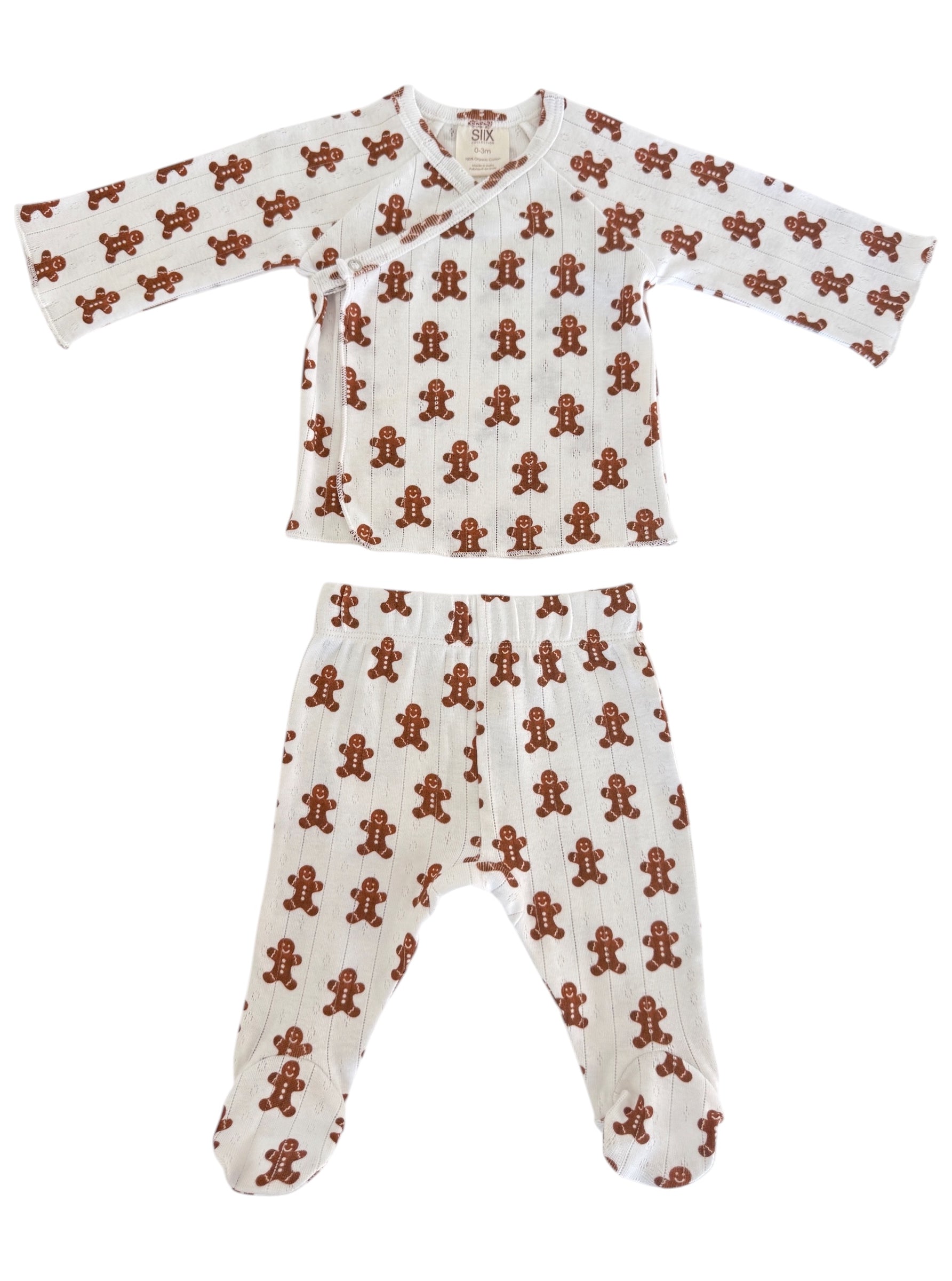 White infant pajamas with a gingerbread man pattern, featuring a top and pants set for cozy wear.