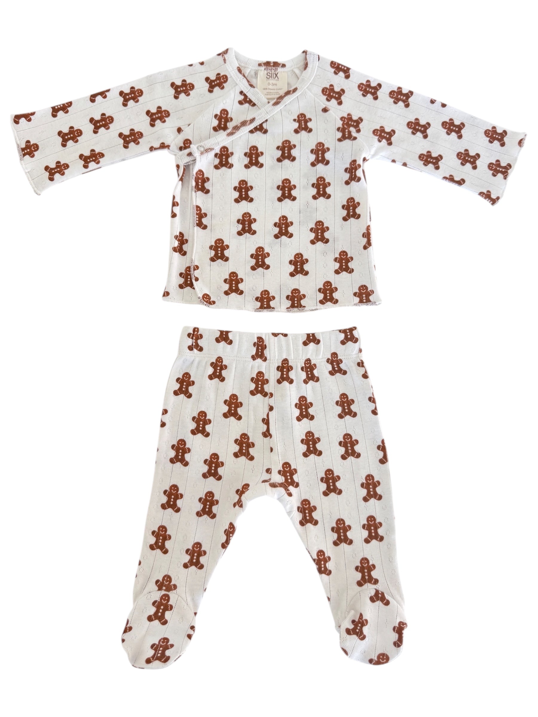 White infant pajamas with a gingerbread man pattern, featuring a top and pants set for cozy wear.
