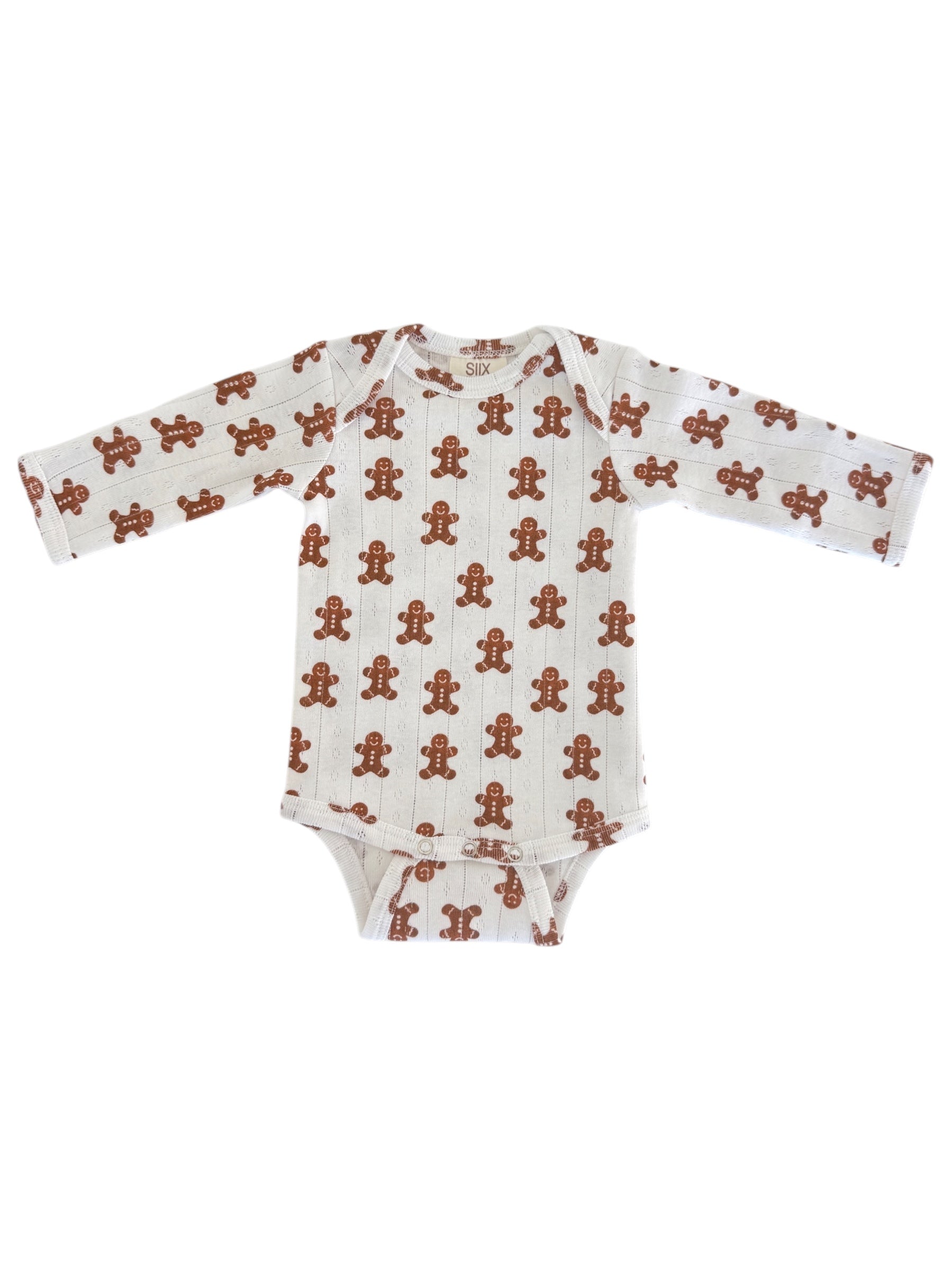 White onesie with gingerbread man print, featuring long sleeves and a snap closure at the bottom.