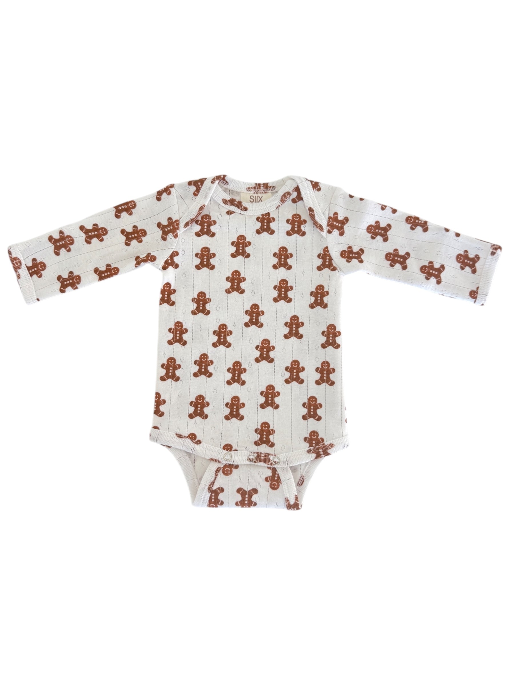 White onesie with gingerbread man print, featuring long sleeves and a snap closure at the bottom.