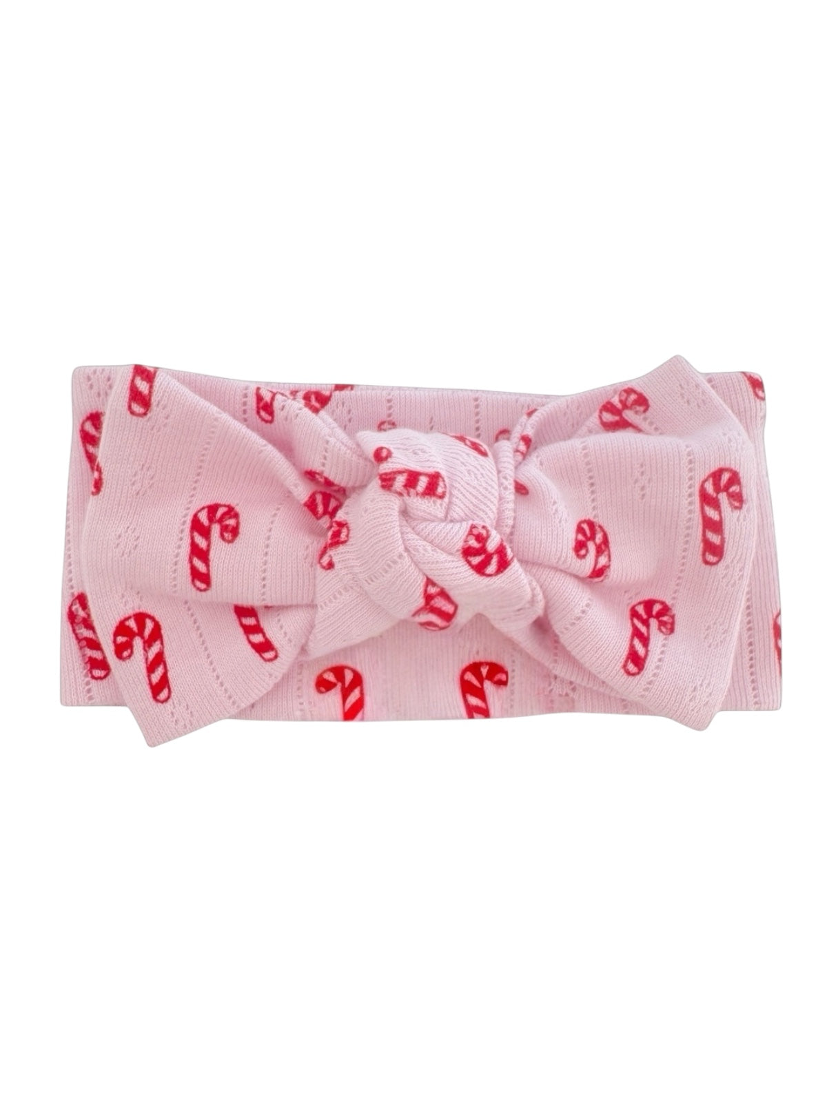 Pink headband with a large bow, featuring a candy cane print.