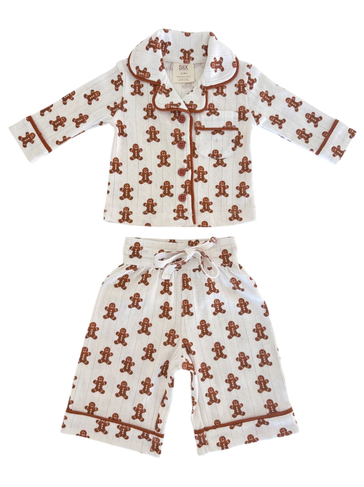 Gingerbread-themed children's pajama set with a collared top and shorts, featuring playful patterns.