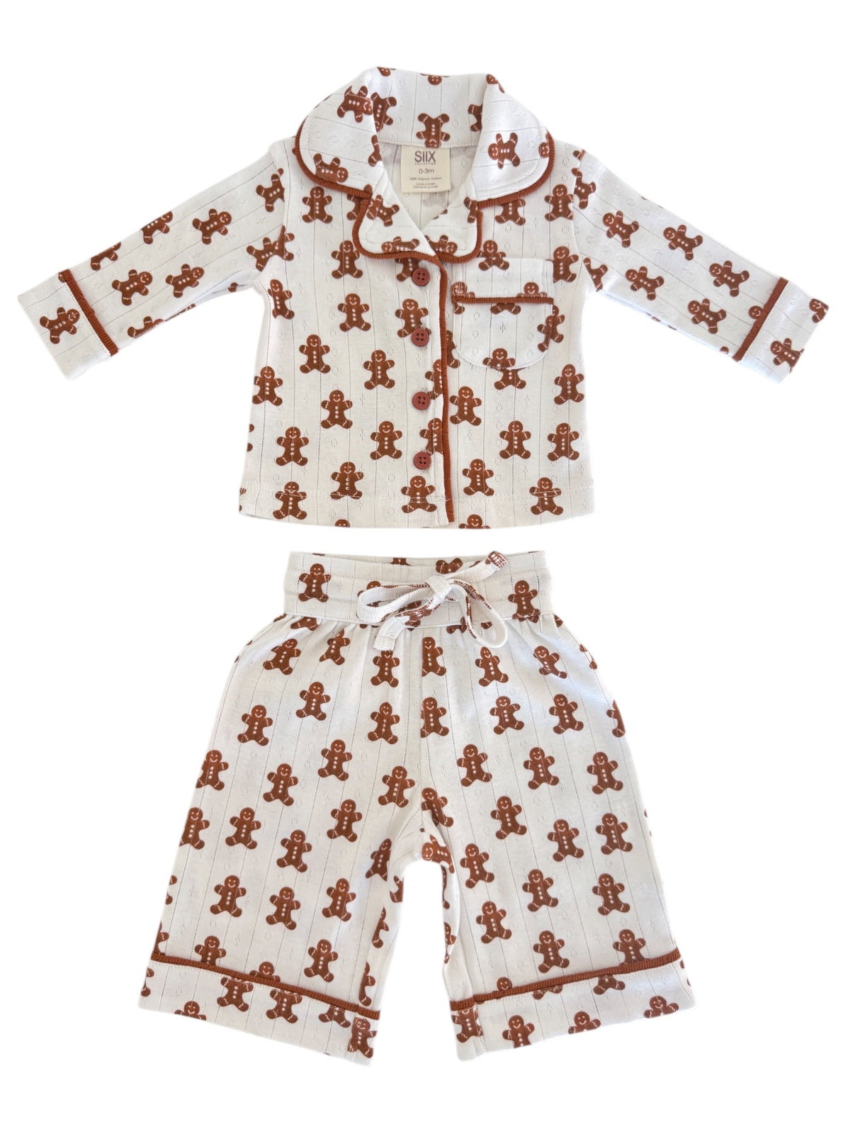Gingerbread-themed children's pajama set with a collared top and shorts, featuring playful patterns.