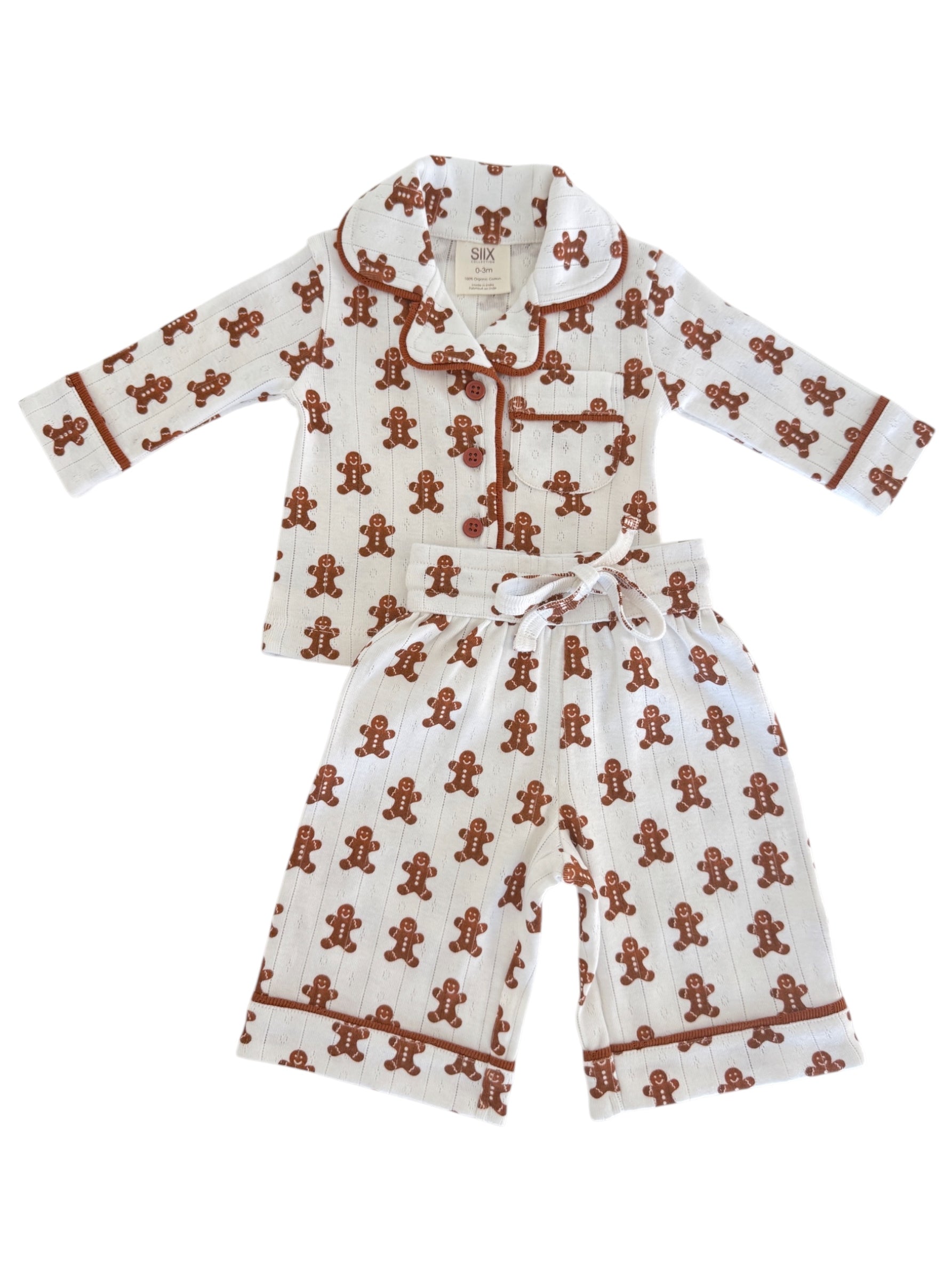 White pajama set with gingerbread man pattern, featuring long sleeves and pants, ideal for cozy nights.