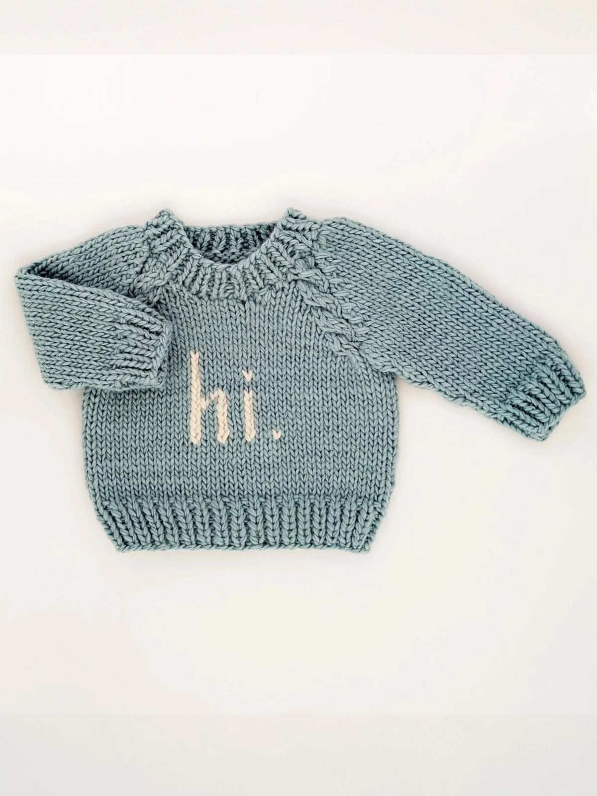 Light blue knitted baby sweater with "hi." in cream, featuring a round neck and ribbed hem.