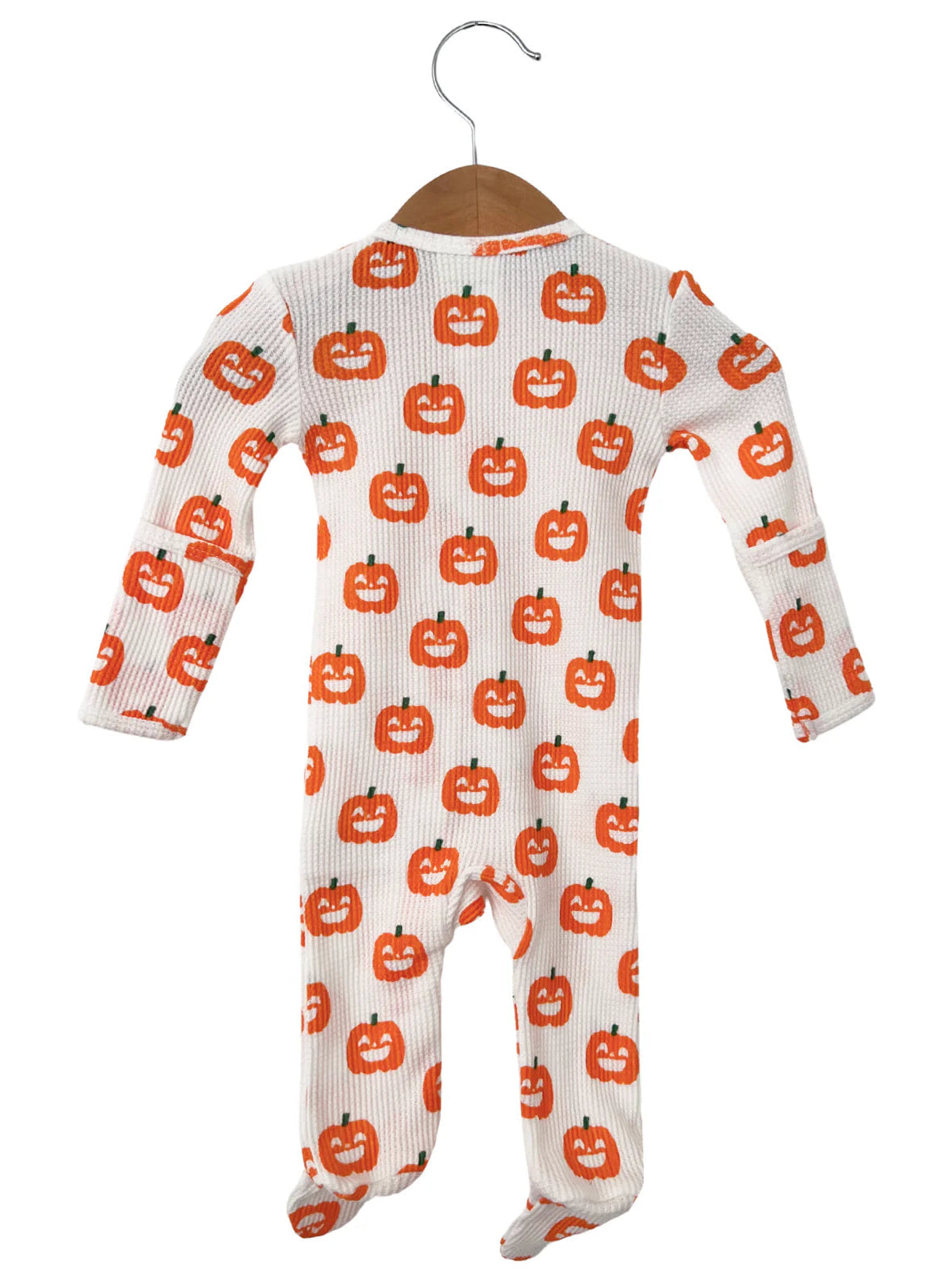 White onesie with orange pumpkin faces, hanging from a wooden hanger. Perfect for Halloween-themed attire.