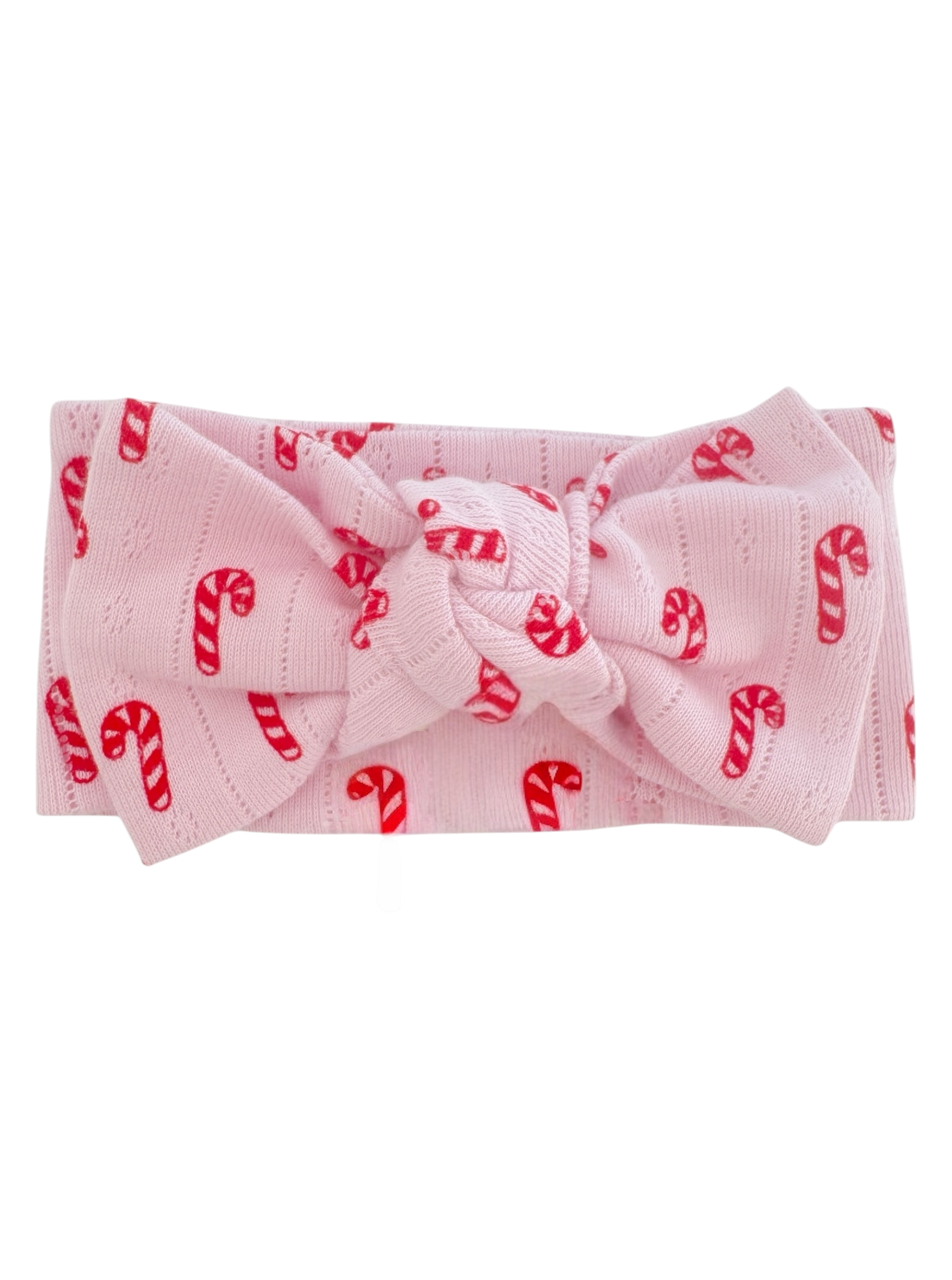 Pink headband with a large bow, decorated with red candy cane patterns. Ideal for festive occasions.