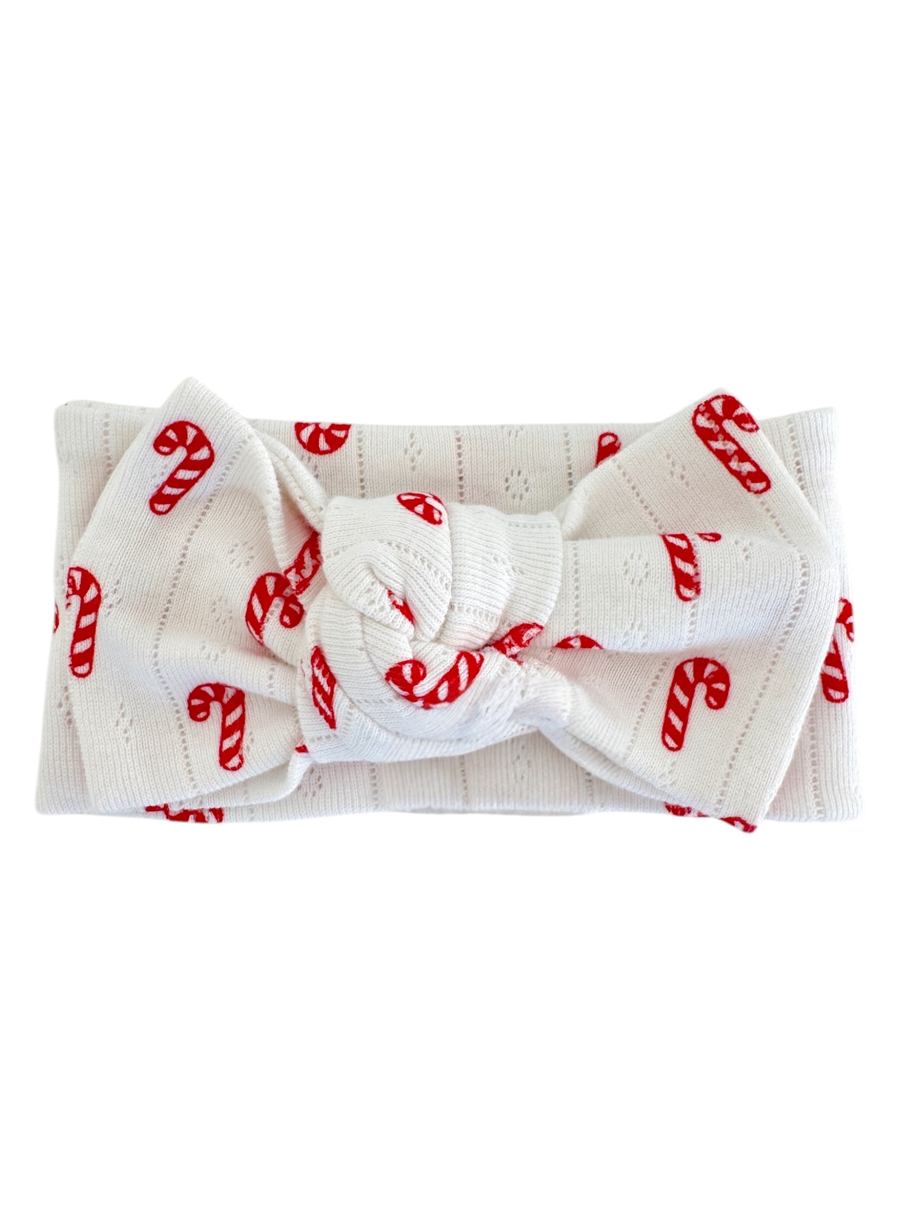 White headband with red candy cane pattern, featuring a knotted bow in the center.