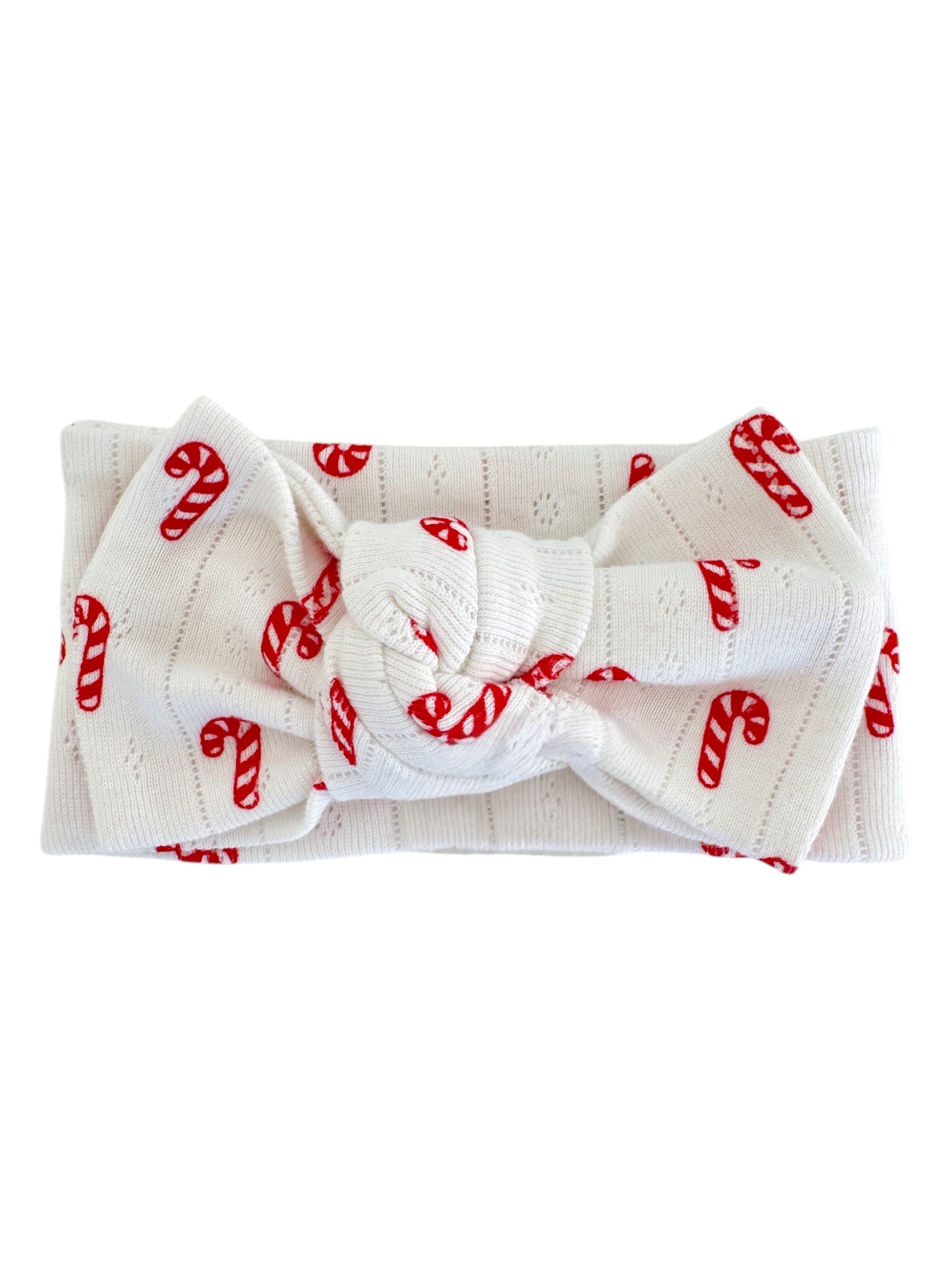 White headband with red candy cane pattern, featuring a knotted bow in the center.