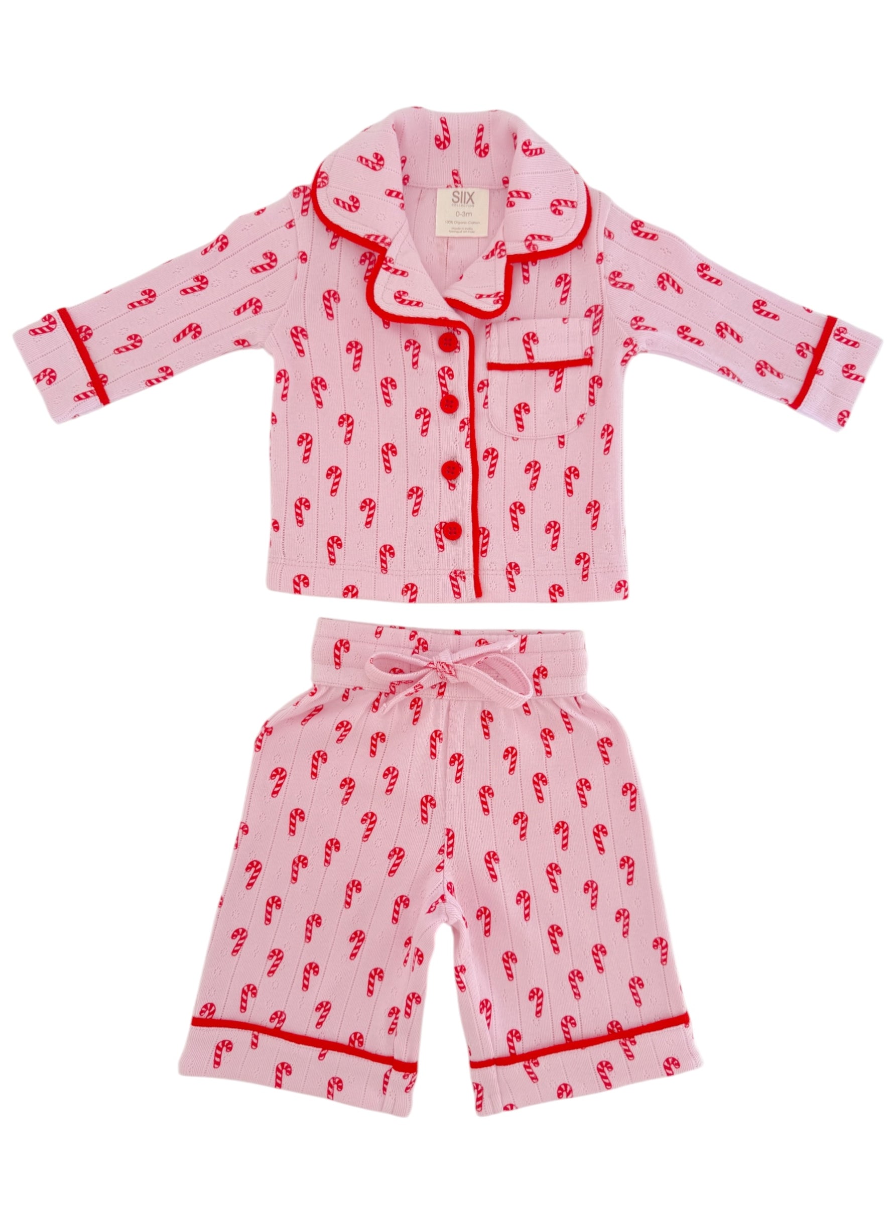 Pink children's pajamas featuring red candy cane patterns, with a collared top and loose-fitting pants.