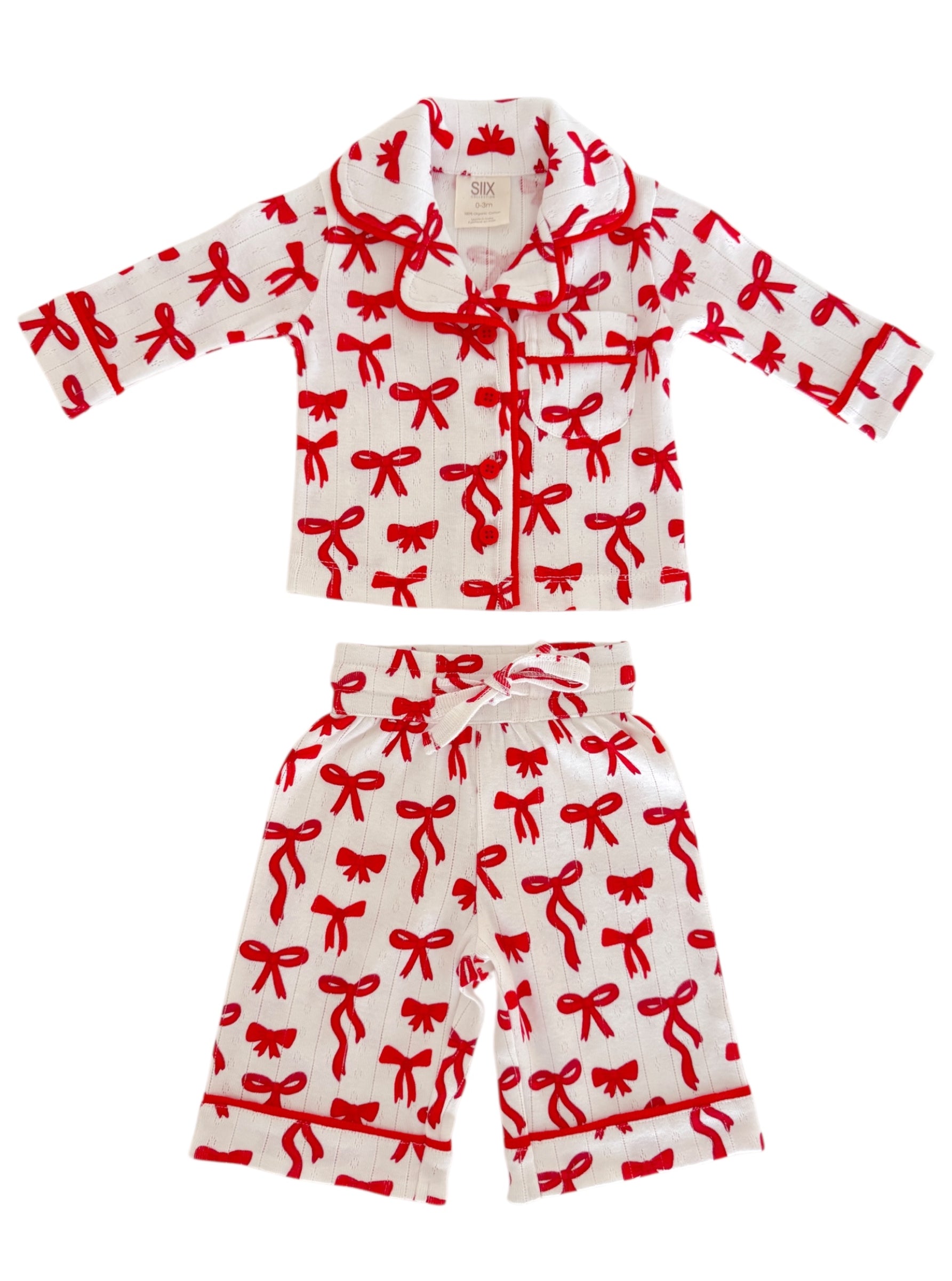 Children's pajama set featuring a white fabric adorned with red bow patterns. Soft and cozy design for bedtime.