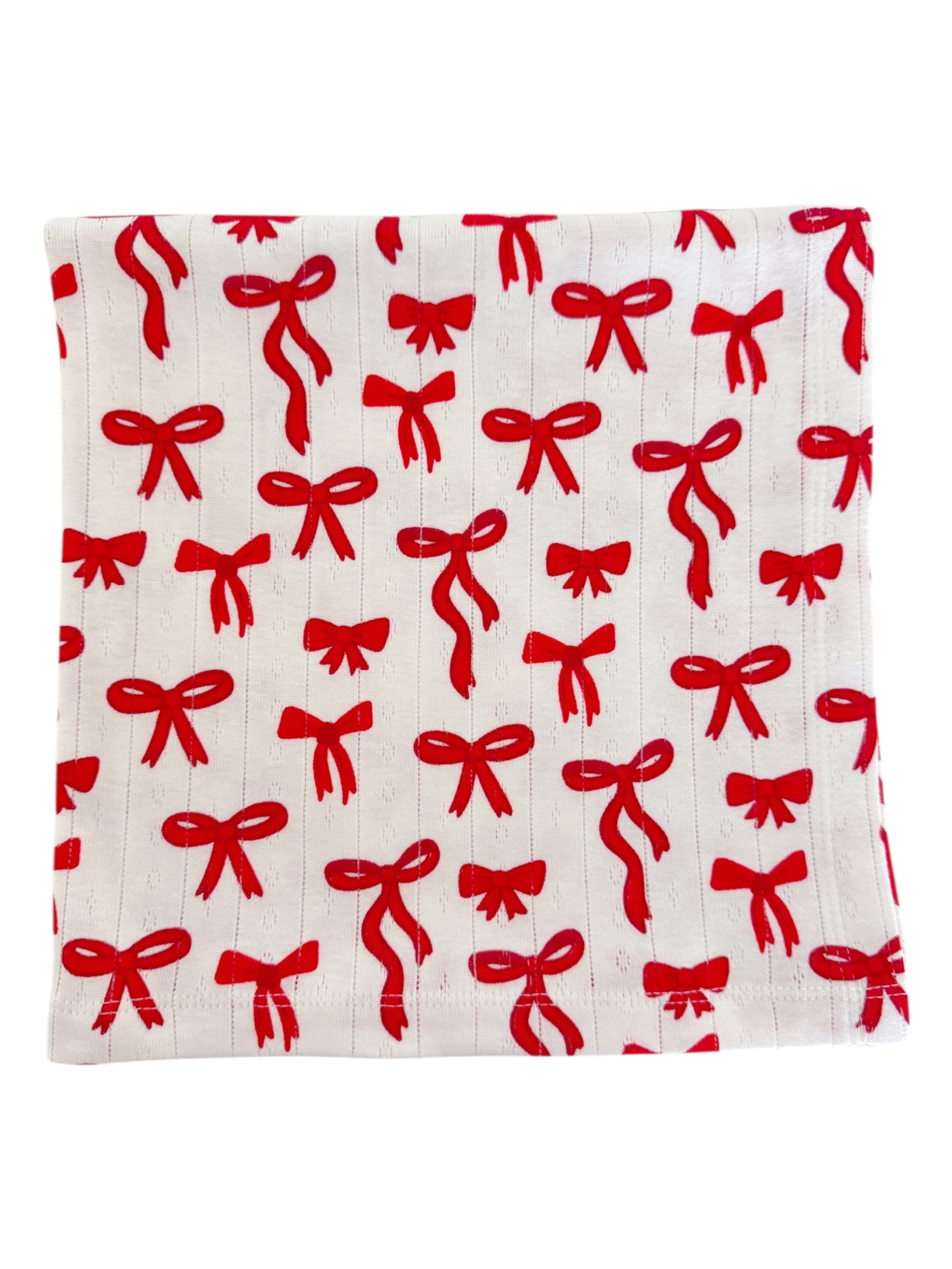 White fabric with a repeating pattern of red bows.