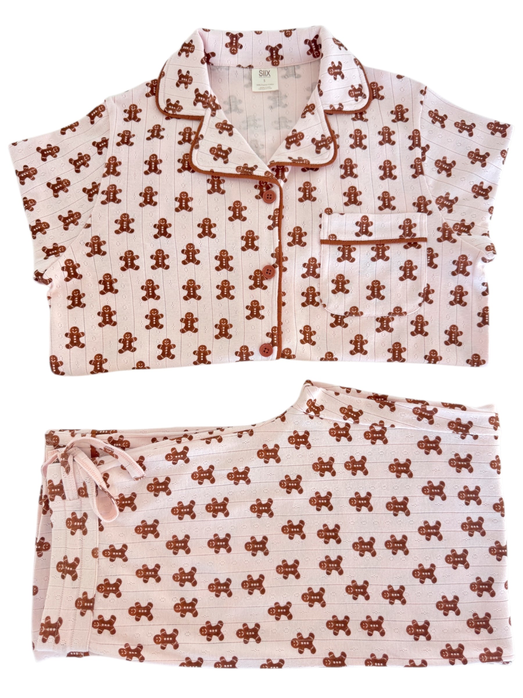 Pink pajama set featuring a gingerbread man pattern, includes a short-sleeve top and matching pants.