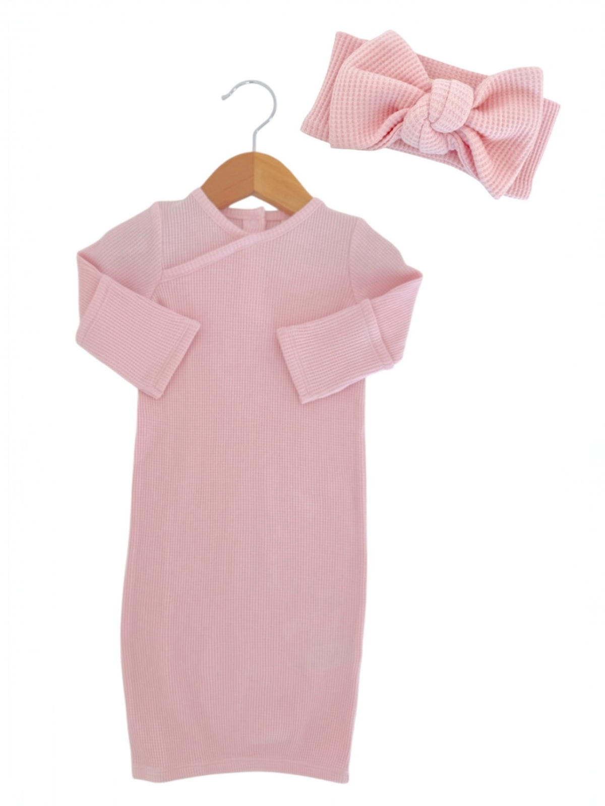 Pink ribbed dress and matching headband on a hanger, perfect for infants or toddlers. Stylish and comfortable outfit.