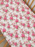 Floral tablecloth featuring pink roses and greenery on a light background.