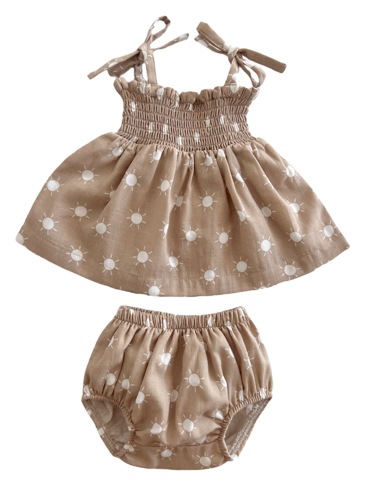 Tan dress and matching bloomers with white sun patterns, designed for toddlers. Perfect for warm weather outings.