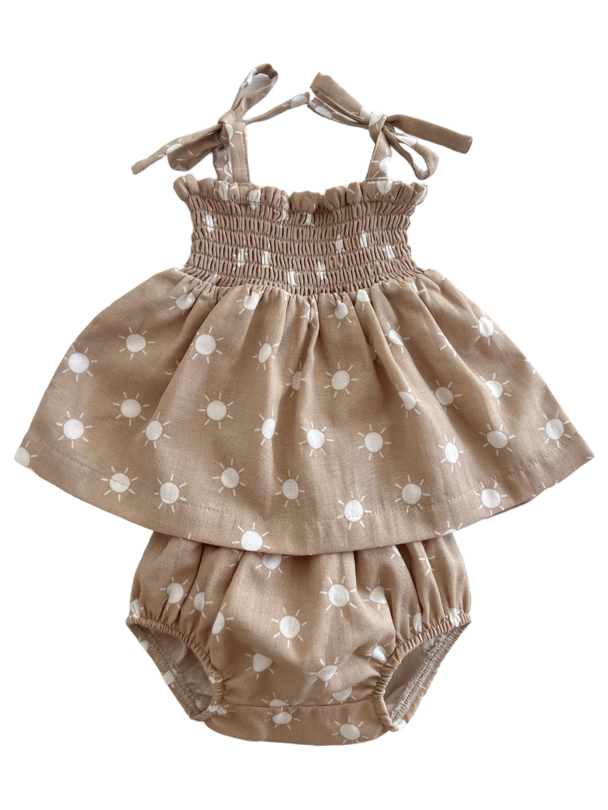 Tan dress with white sun patterns and matching bloomers, featuring adjustable straps and smocked bodice.