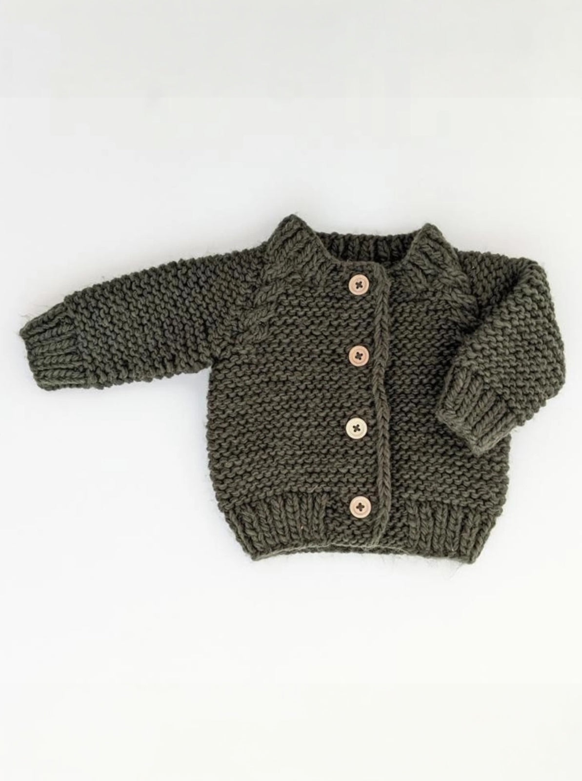Knitted olive green baby cardigan with wooden buttons on a white background.