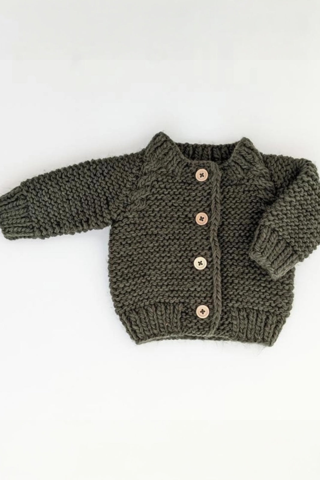 Knitted olive green baby cardigan with wooden buttons on a white background.