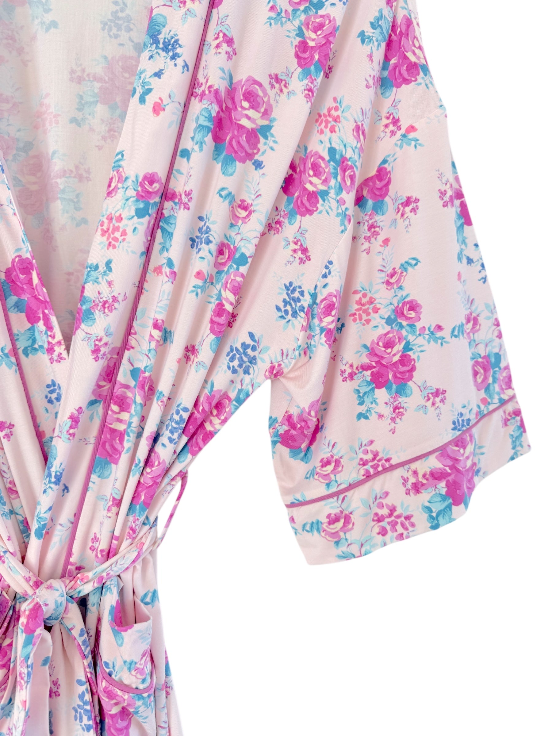 Floral pink robe with blue and purple flowers, featuring a tie waist and loose sleeves.