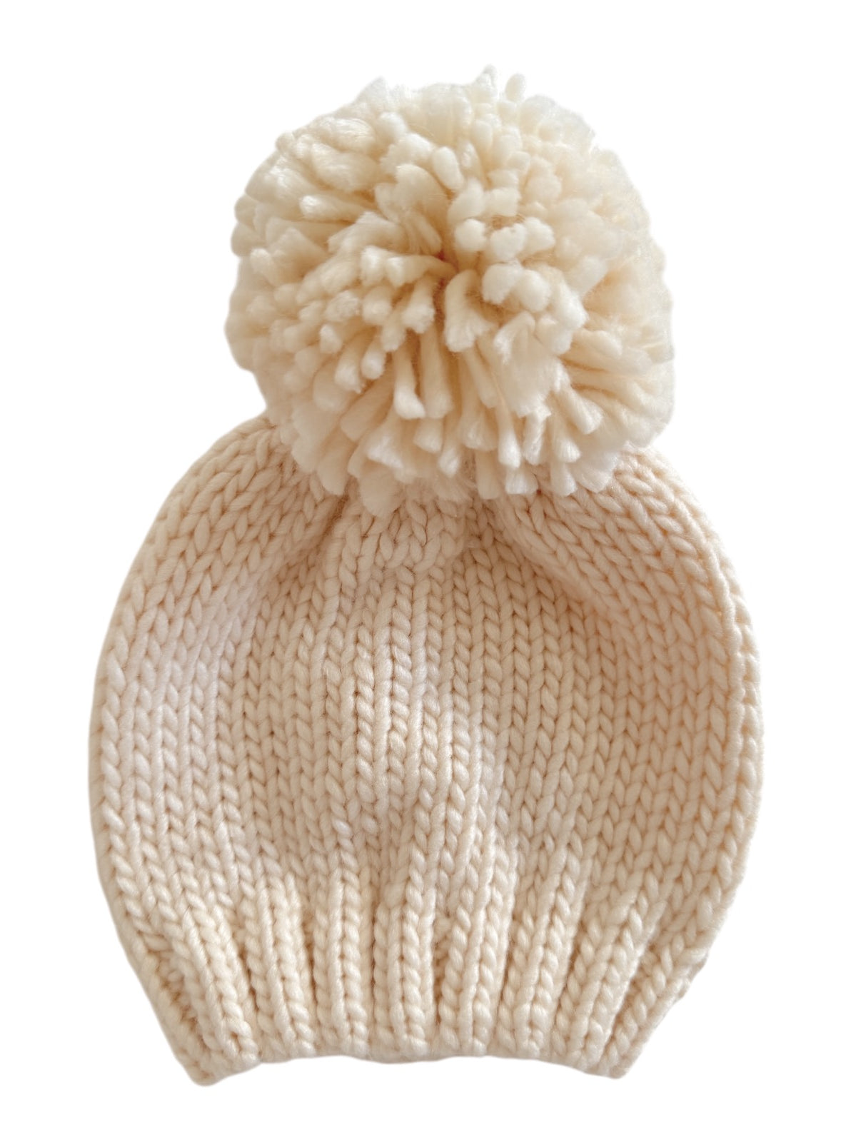 Cream knitted hat with a fluffy pom-pom on top, ideal for cold weather and stylish outfits.