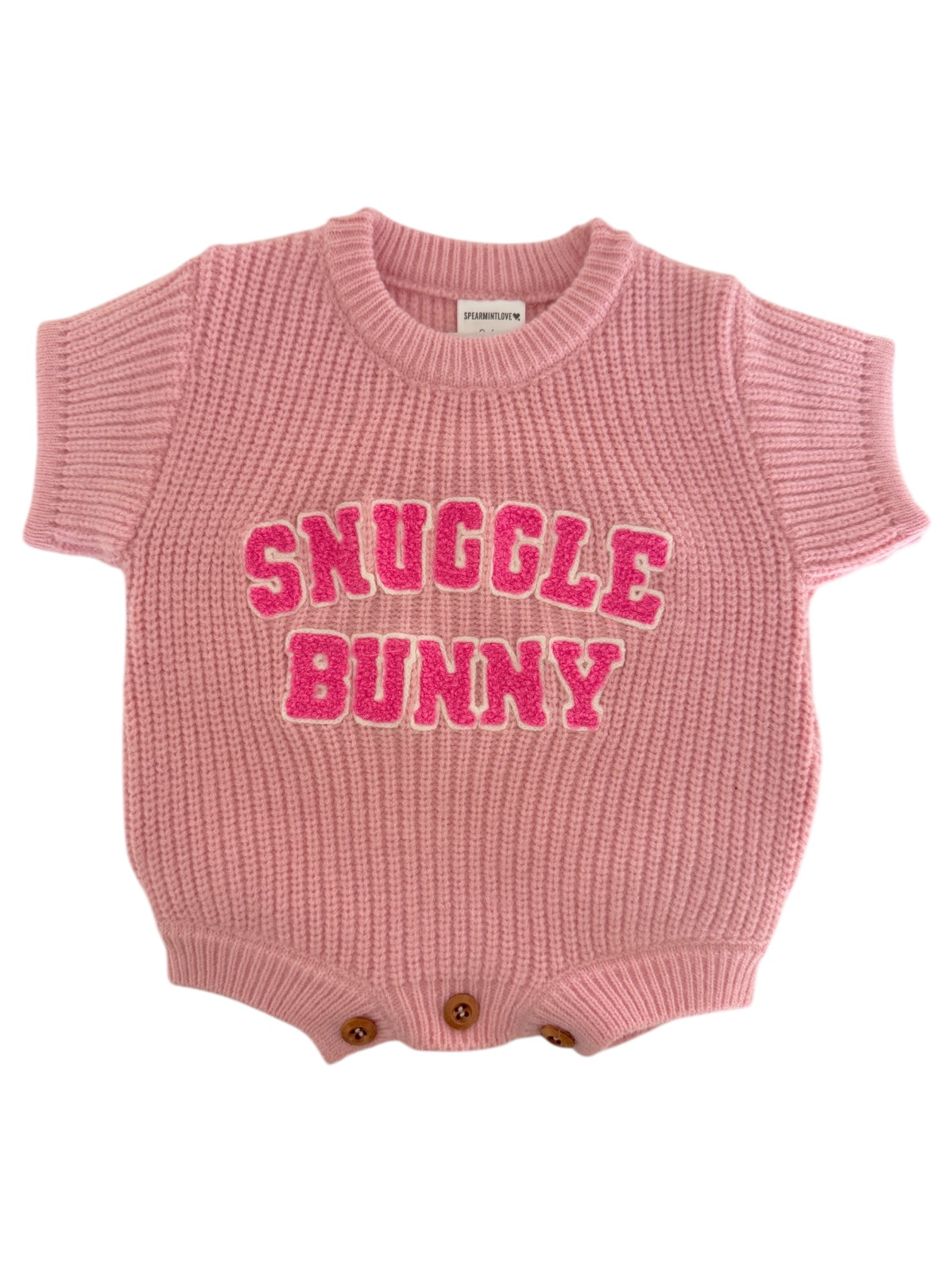 Pink knit baby onesie with "Snuggle Bunny" text in bold, playful letters. Ideal for cozy occasions.