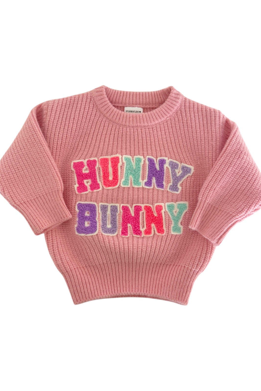 Pink sweater with "HUNNY BUNNY" in colorful letters on the front, featuring a ribbed design and short sleeves.