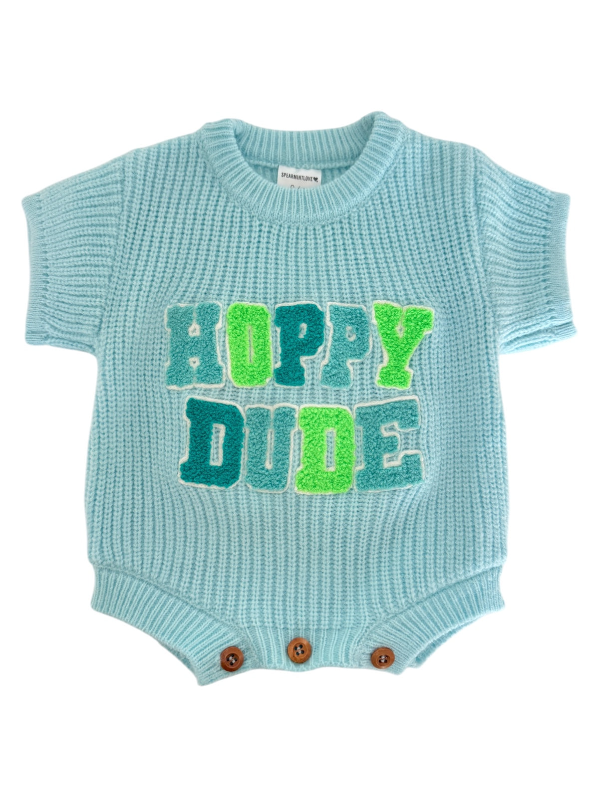 Light blue knitted baby romper with "Hoppy Dude" in bold green and blue letters. Features button closures.