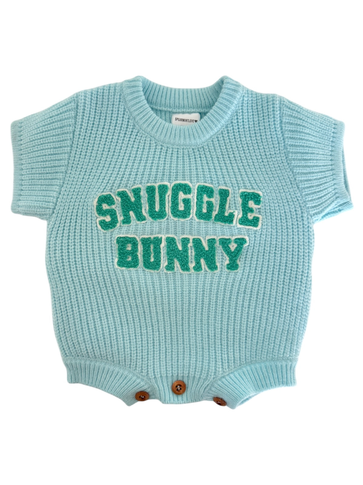 Light blue knitted baby onesie with "Snuggle Bunny" in green letters and button closures at the bottom.