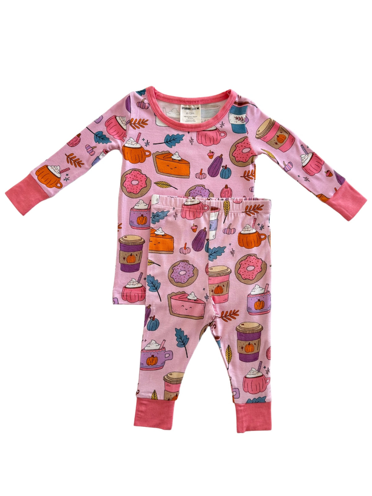 Pink pajama set featuring dessert-themed patterns, including cakes, donuts, and autumn leaves. Cute and cozy for children.