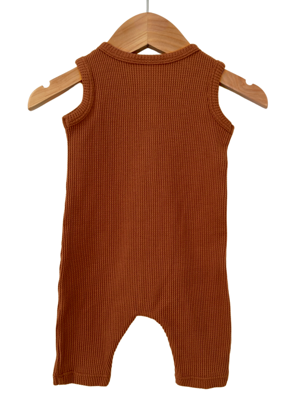 Brown ribbed baby romper hanging on a wooden hanger against a white background.