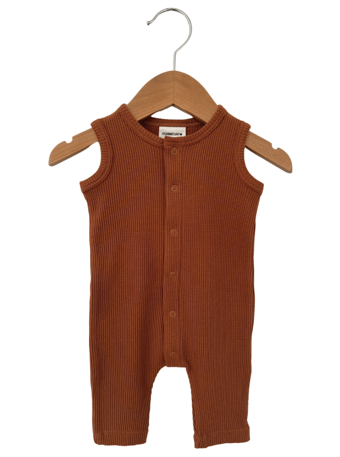 Terracotta ribbed baby romper on a wooden hanger. Perfect for casual or playtime wear.