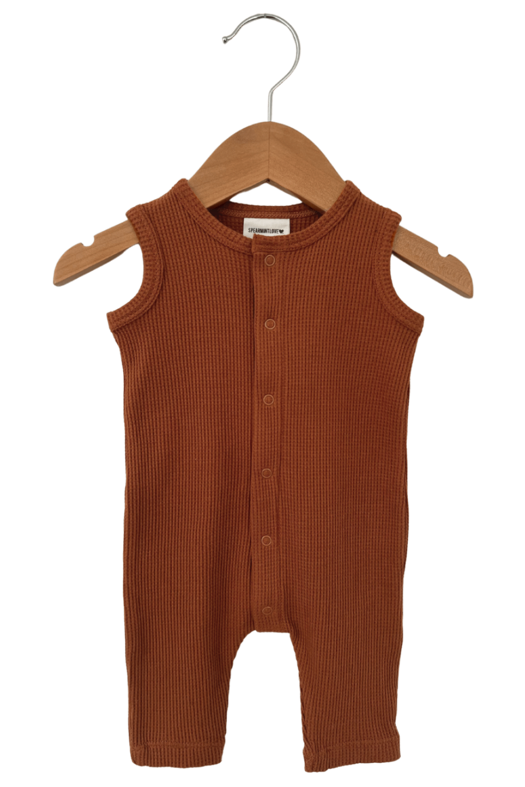 Terracotta ribbed baby romper on a wooden hanger. Perfect for casual or playtime wear.