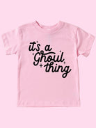 Pink t-shirt with the text "it's a Ghoul thing" in black lettering and playful star accents.