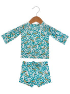 Kid's swim set featuring a long-sleeve top and matching shorts with a turquoise and banana pattern.