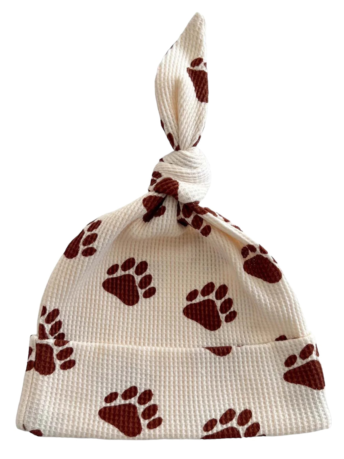 White baby hat with brown paw prints and a tied top. Ideal for stylish and cozy outfits.