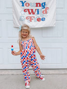 Smiling girl in a colorful outfit holding a popsicle, with a "Young Wild & Free" banner in the background.