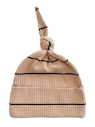 Beige ribbed knit baby hat with a knot on top and black stripes.
